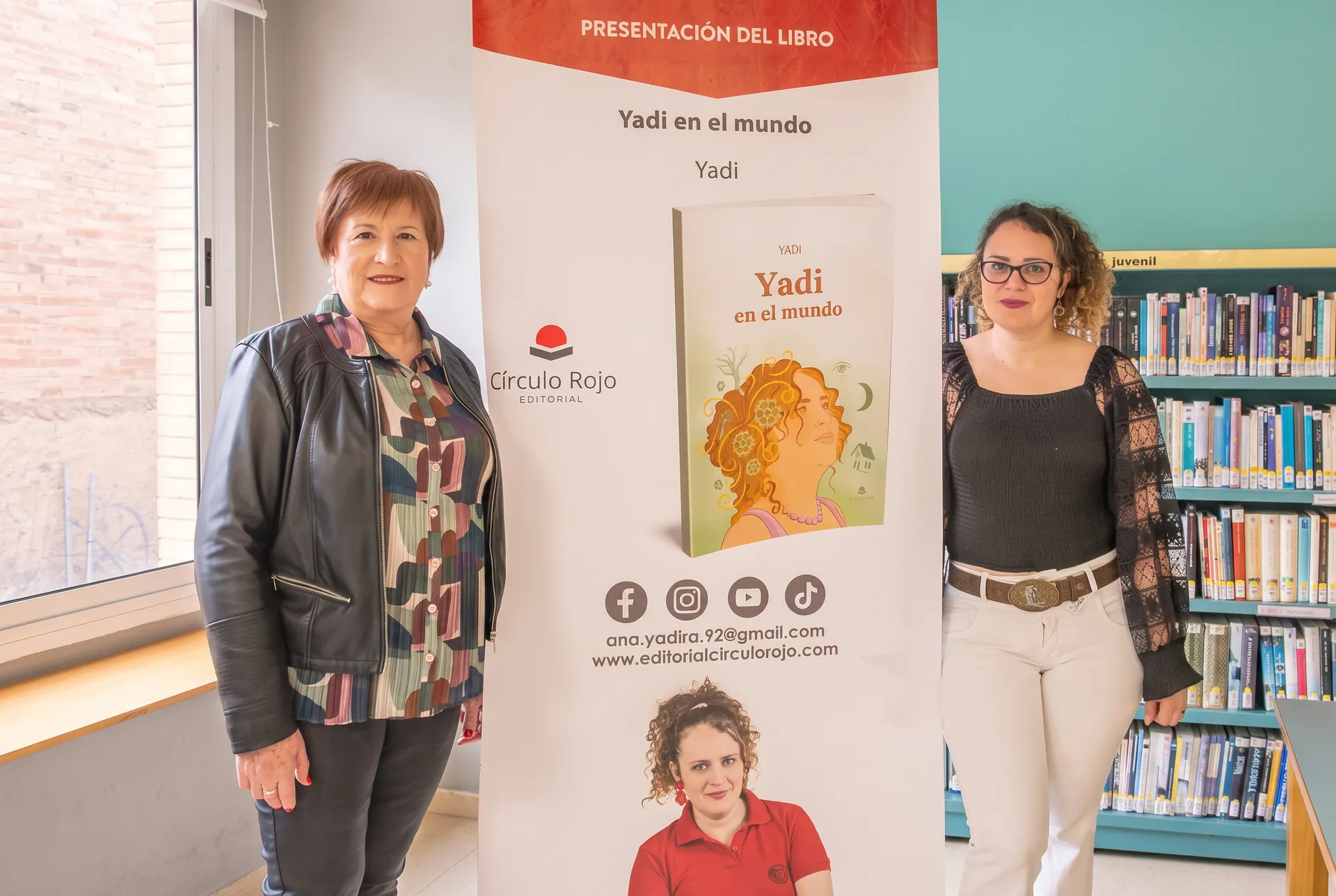 Yadi junto al cartel de la presentación del libro