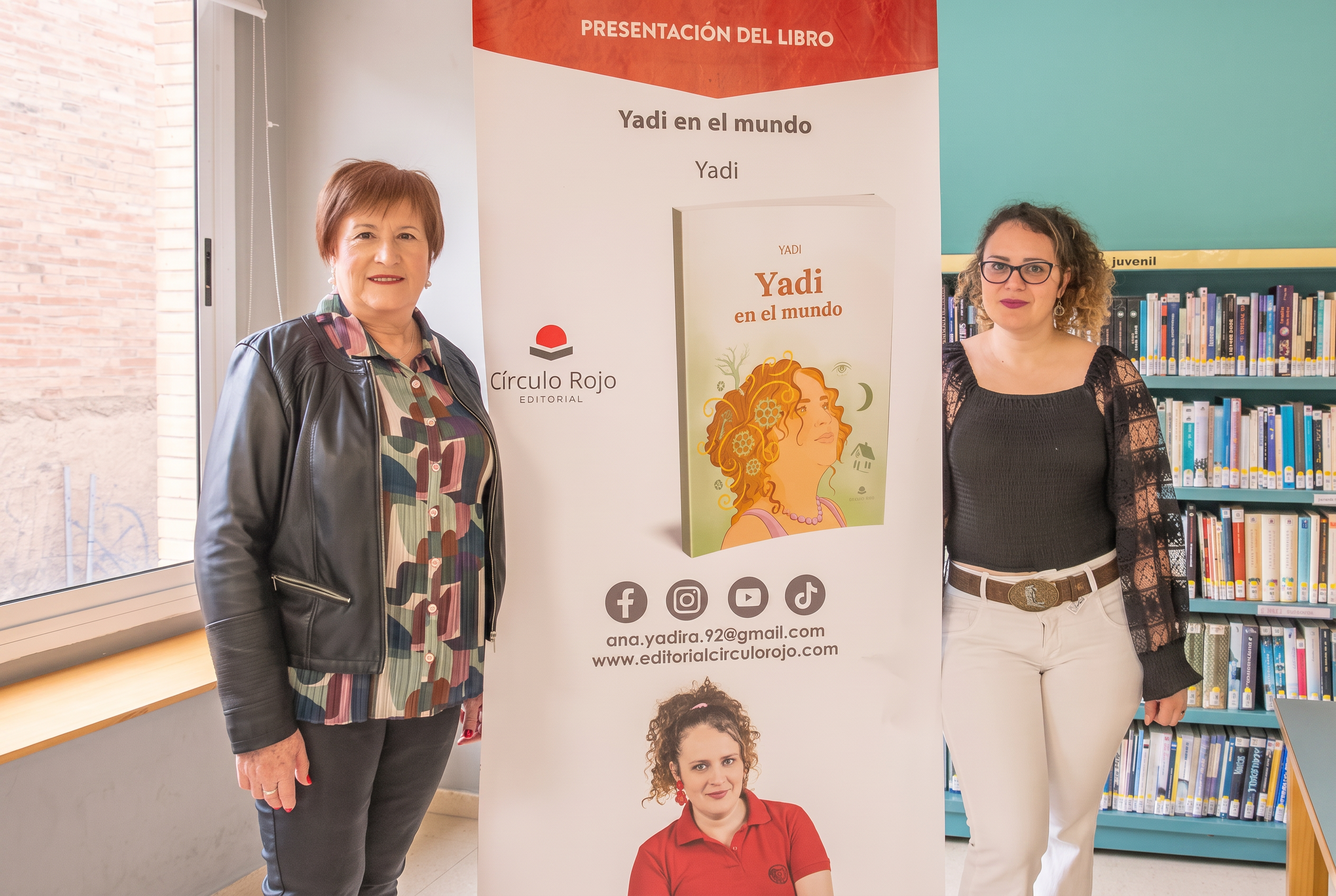 Yadi junto al cartel de la presentación del libro
