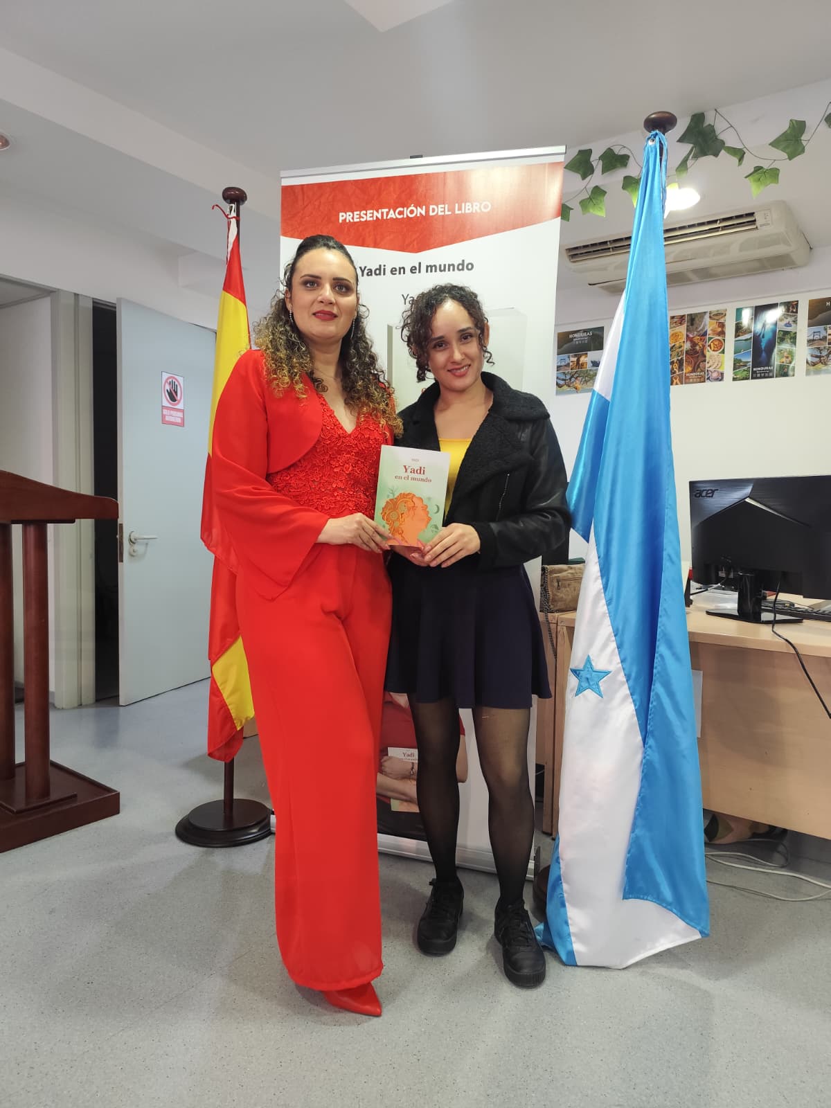 Yadi Villanueva junto a una asistente con su libro en el Consulado General de Honduras