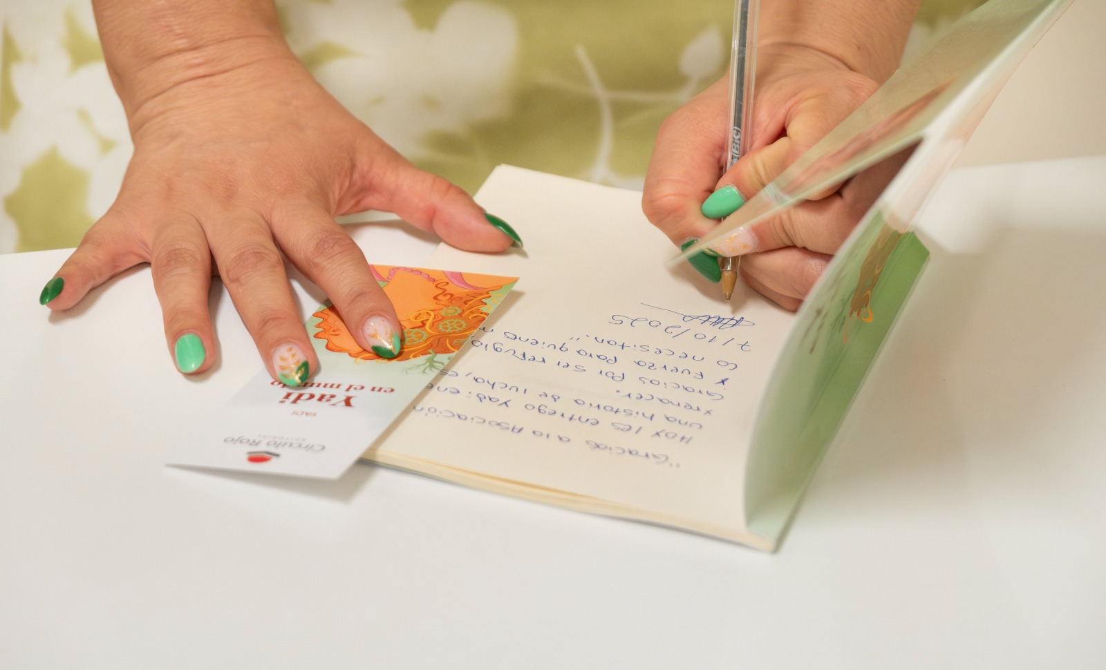 Yadi escribiendo una dedicatoria en un ejemplar de su libro