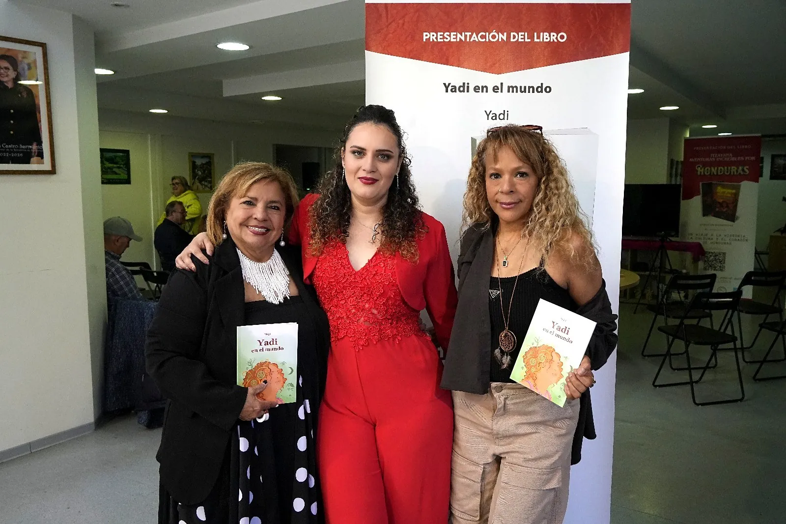 Yadi Villanueva con dos lectoras sosteniendo el libro Yadi en el mundo en el Consulado General de Honduras en Barcelona