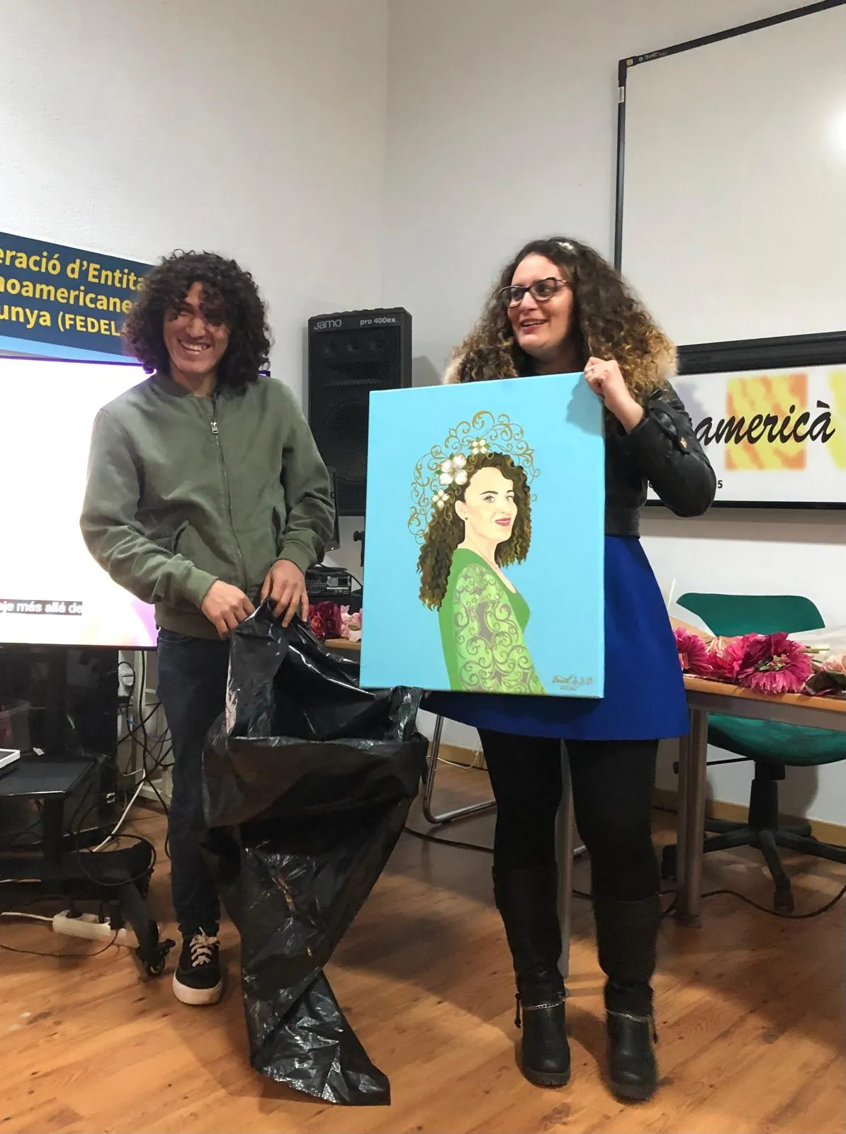 Yadi Villanueva recibe el retrato pintado por David durante la presentación de su libro en FEDELATINA, Barcelona