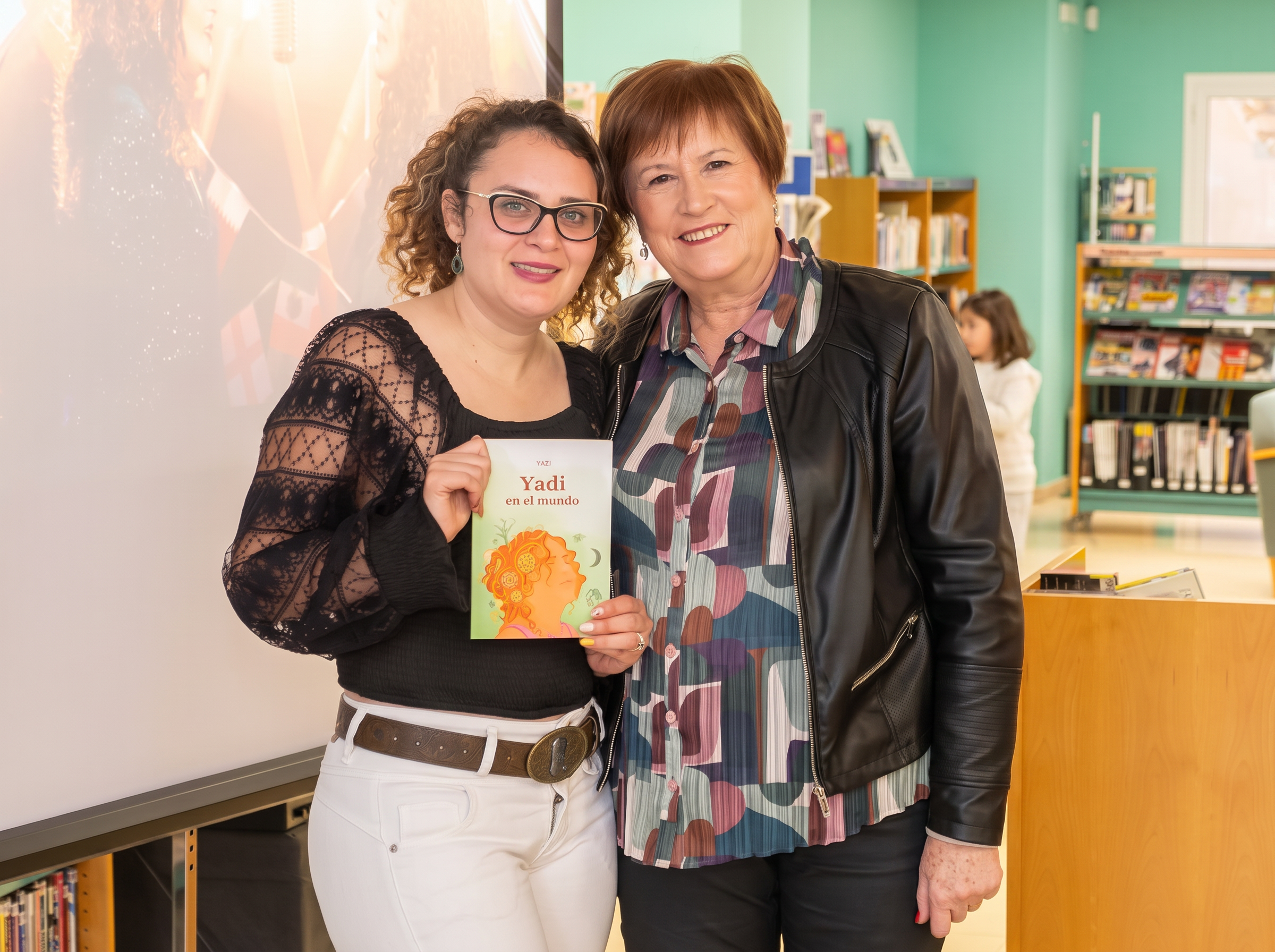 Yadi junto a una lectora sosteniendo el libro