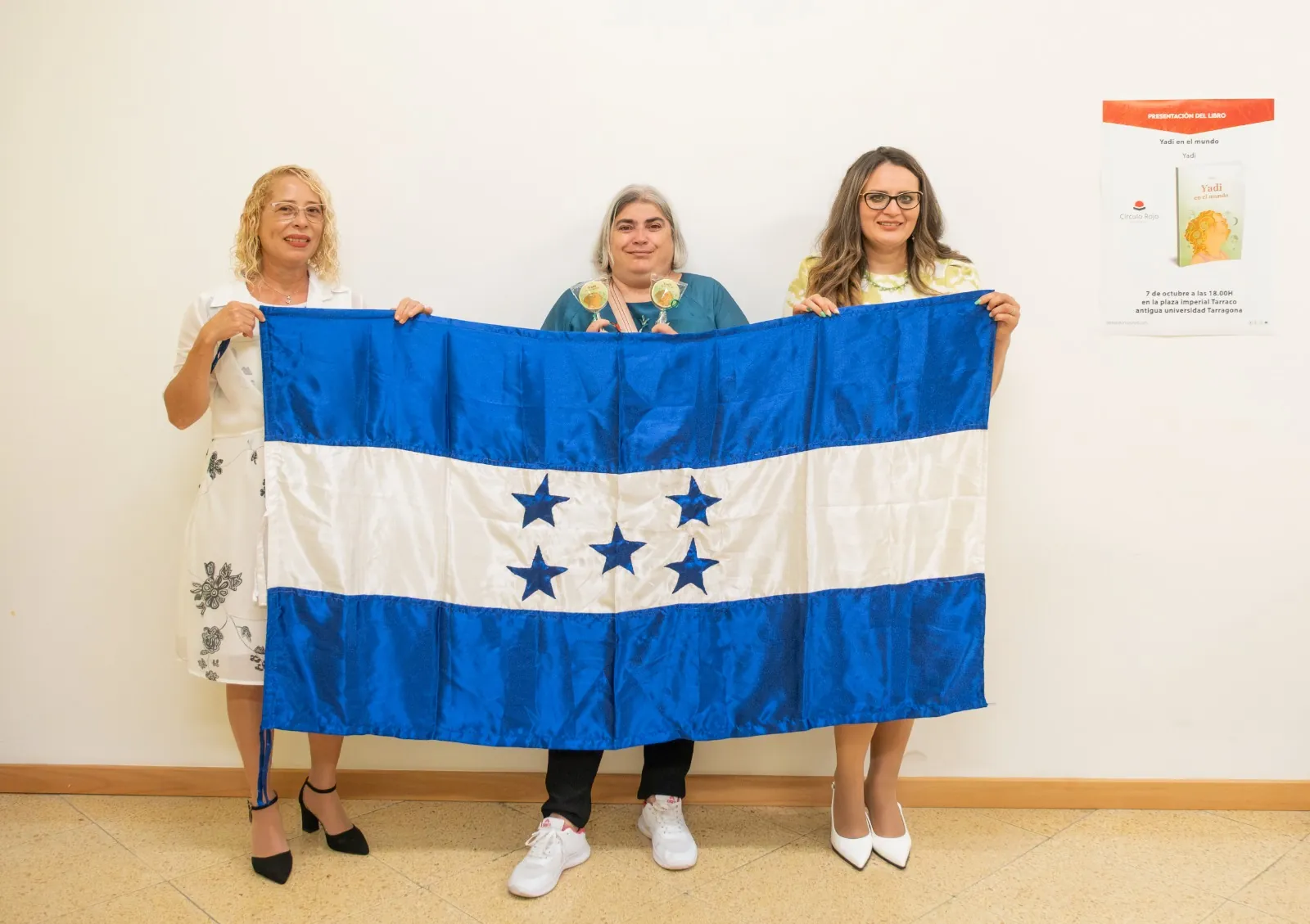 Yadi Villanueva y asistentes sosteniendo la bandera de Honduras en Tarragona